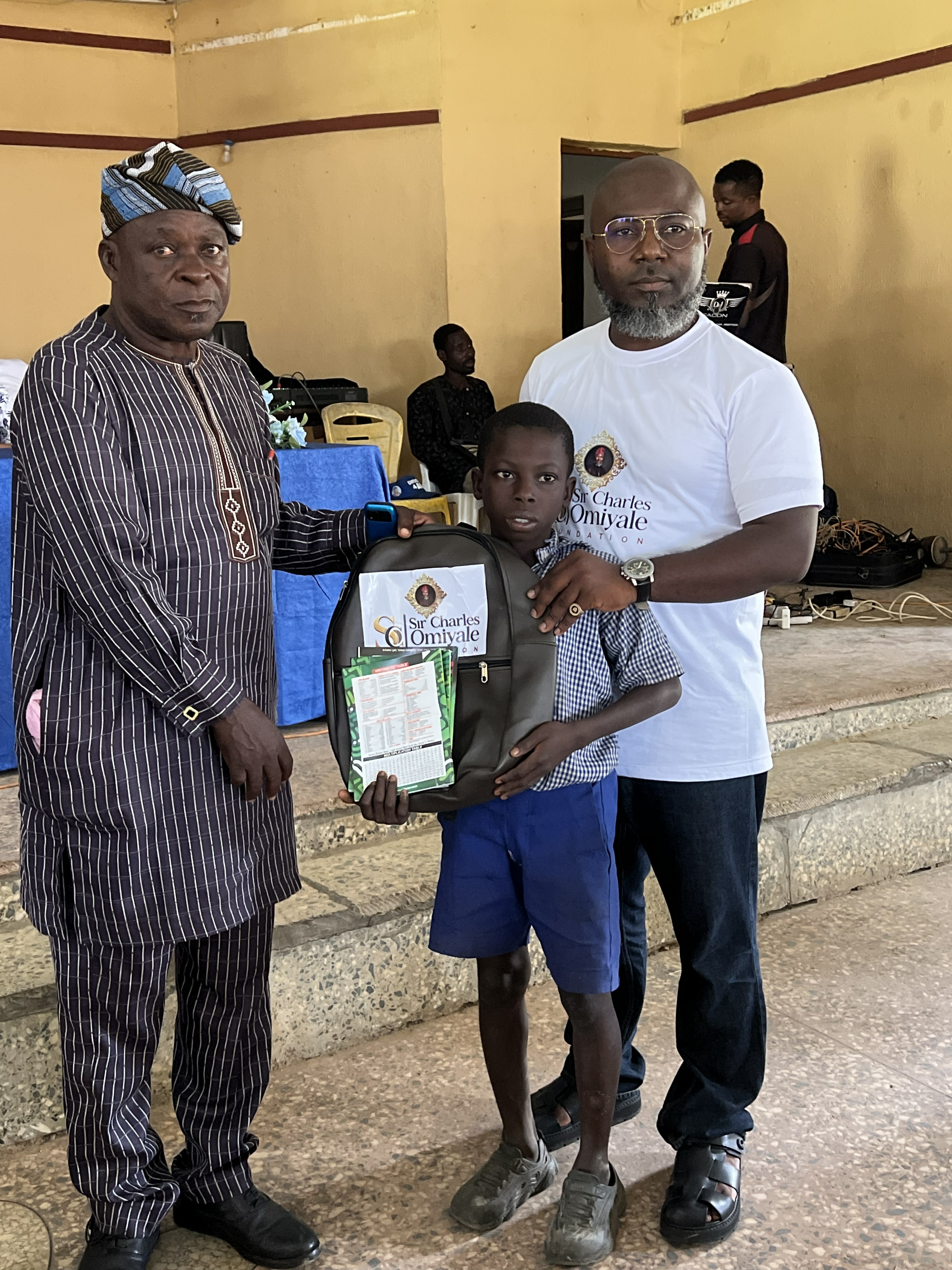 Donation of school supplies and bags by Sir Charles Omiyale alongside the secretary of Igabjo Development Association (IDA)